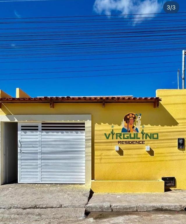 a yellow building with a sign on the side of it at Virgulino Residence in Piranhas