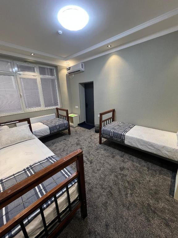 a room with three beds in a room at Hostel Mevazor in Katartal