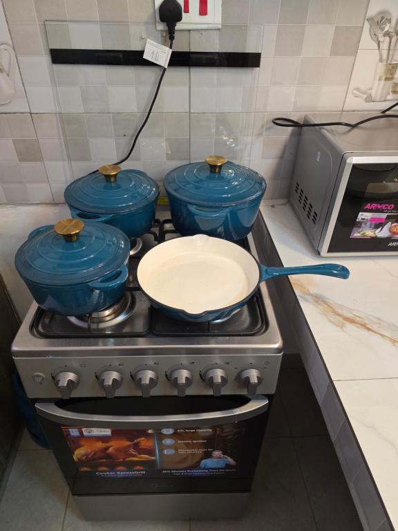 a stove with two pots and a pan on it at Rio Cabins in Nyeri