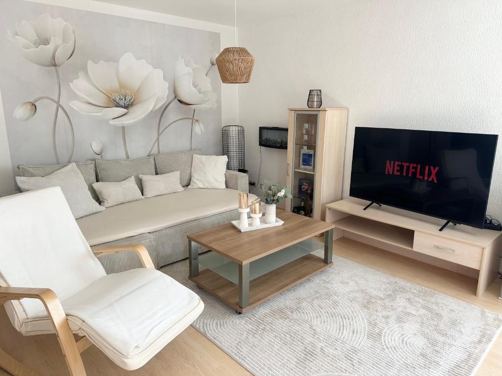 a living room with a couch and a tv at La Pura Vida in Bühlertann