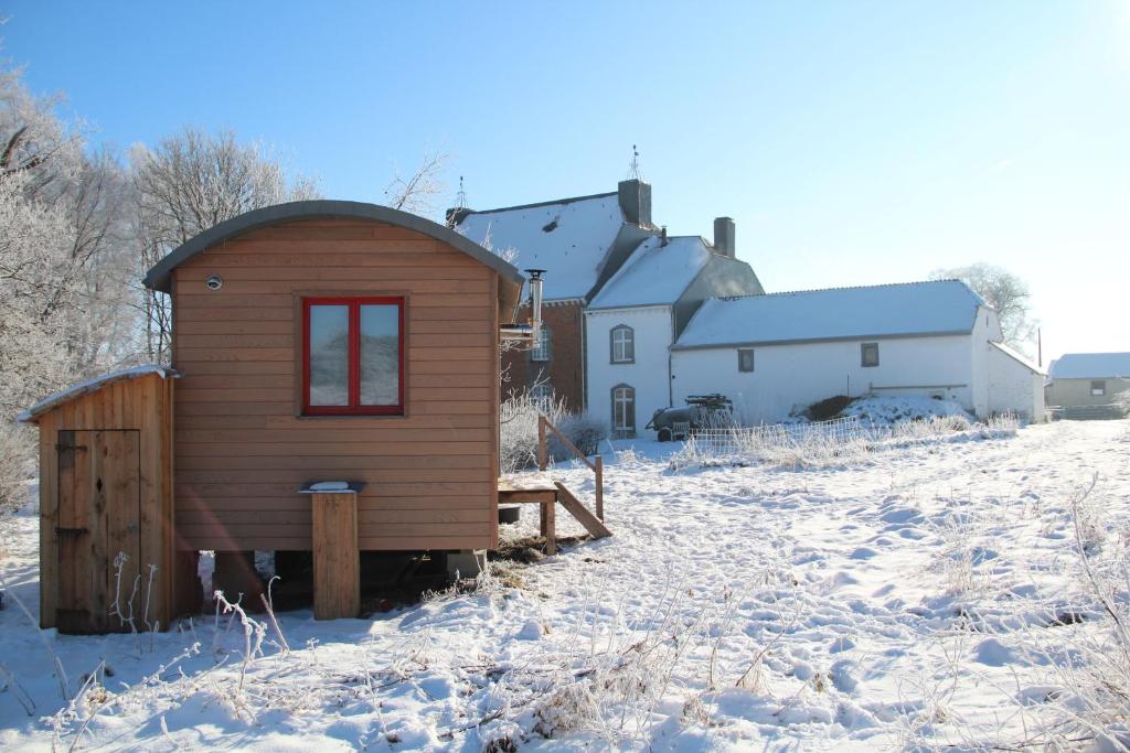 a small wooden cabin in a snow covered yard at La roulotte Ô Cwèrbâs in Gouvy