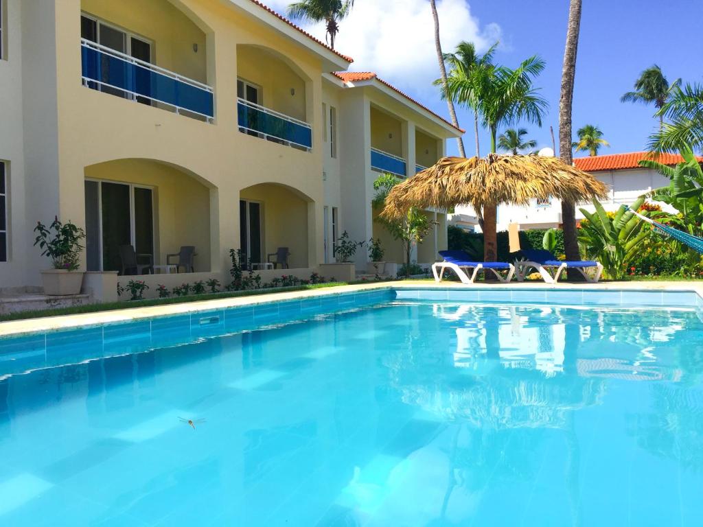a swimming pool in front of a villa at Las Galeras Hotel in Las Galeras