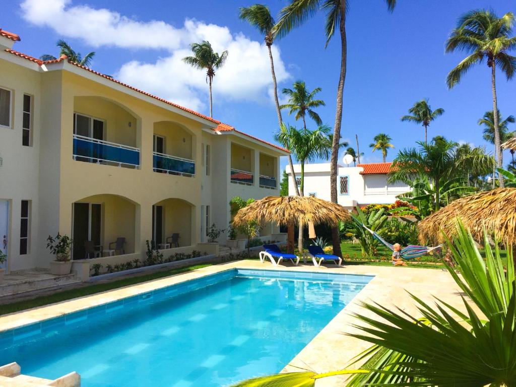 a villa with a swimming pool and palm trees at Las Galeras Hotel in Las Galeras