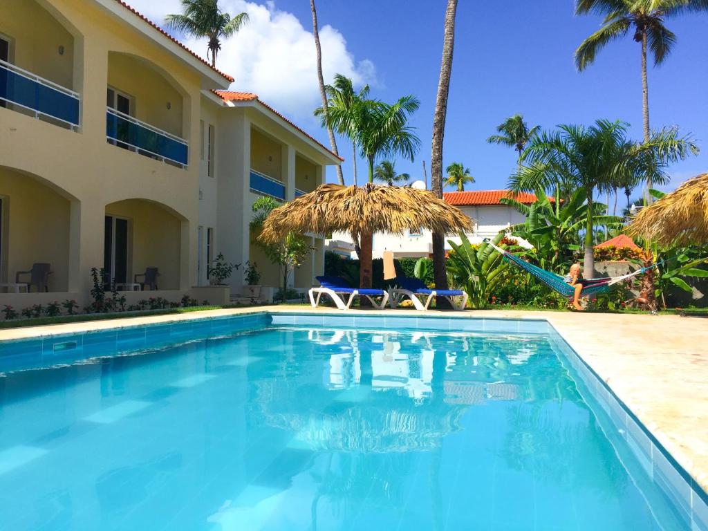 a swimming pool in front of a villa at Las Galeras Hotel in Las Galeras
