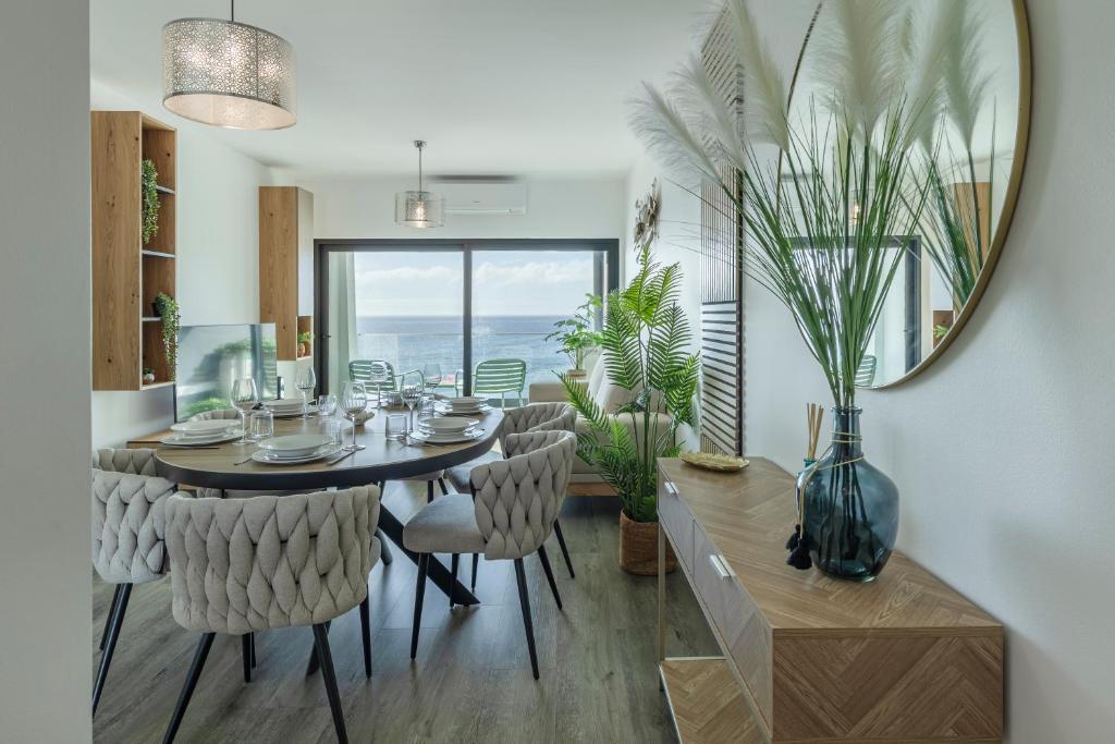 a dining room with a table and chairs and a mirror at Alma do mar luxury - Ocean front in Gaula