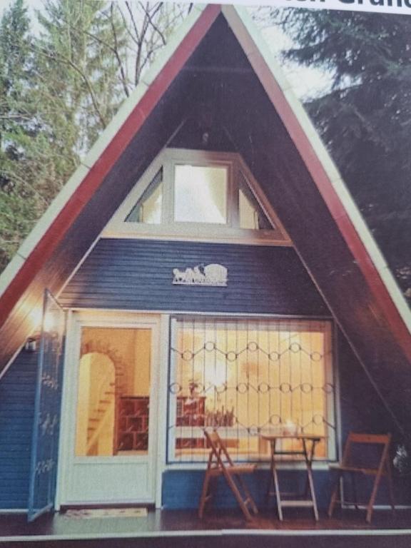 a small house with a gambrel roof with a window at Abenteuerurlaub im Tannenwald in Ilmenau