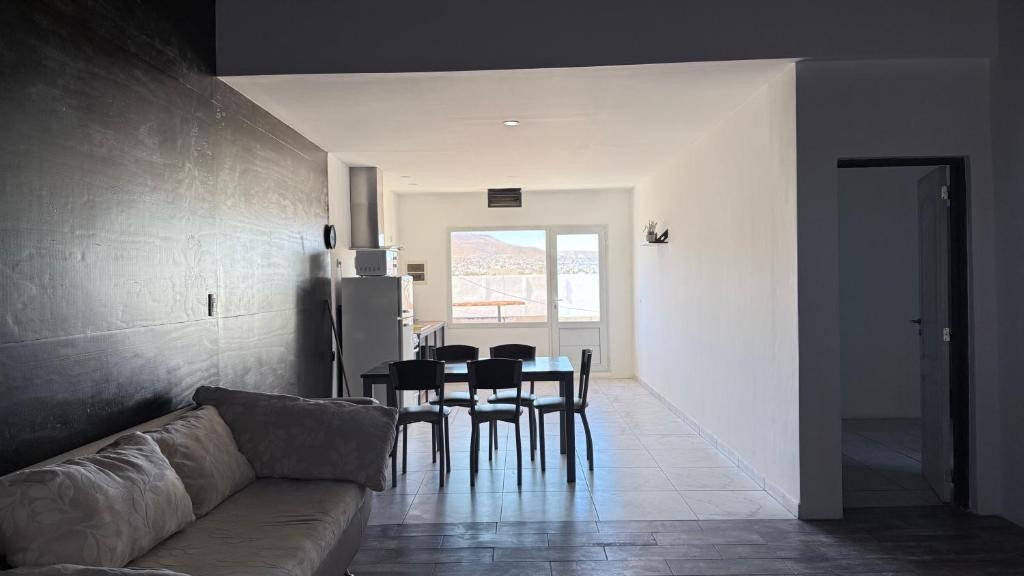 a living room with a couch and a table and chairs at Softi Sur in Comodoro Rivadavia
