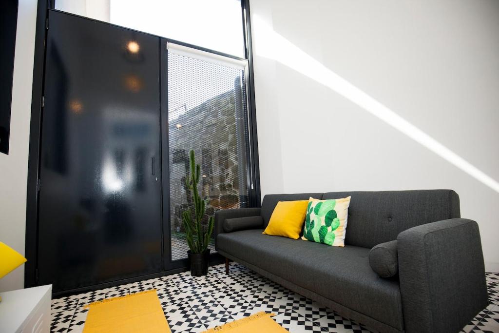 a living room with a couch and a window at GET a Cactus and Books studio in Porto