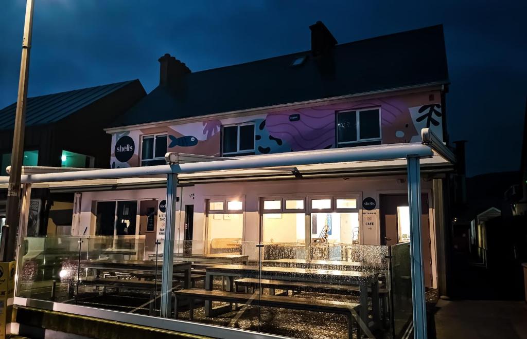 a pink house with lights on it at night at Beachfront Apartments in Sligo