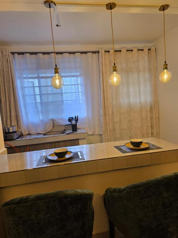 a kitchen with a counter with two plates and lights at Misty Cabins in Ruringʼu