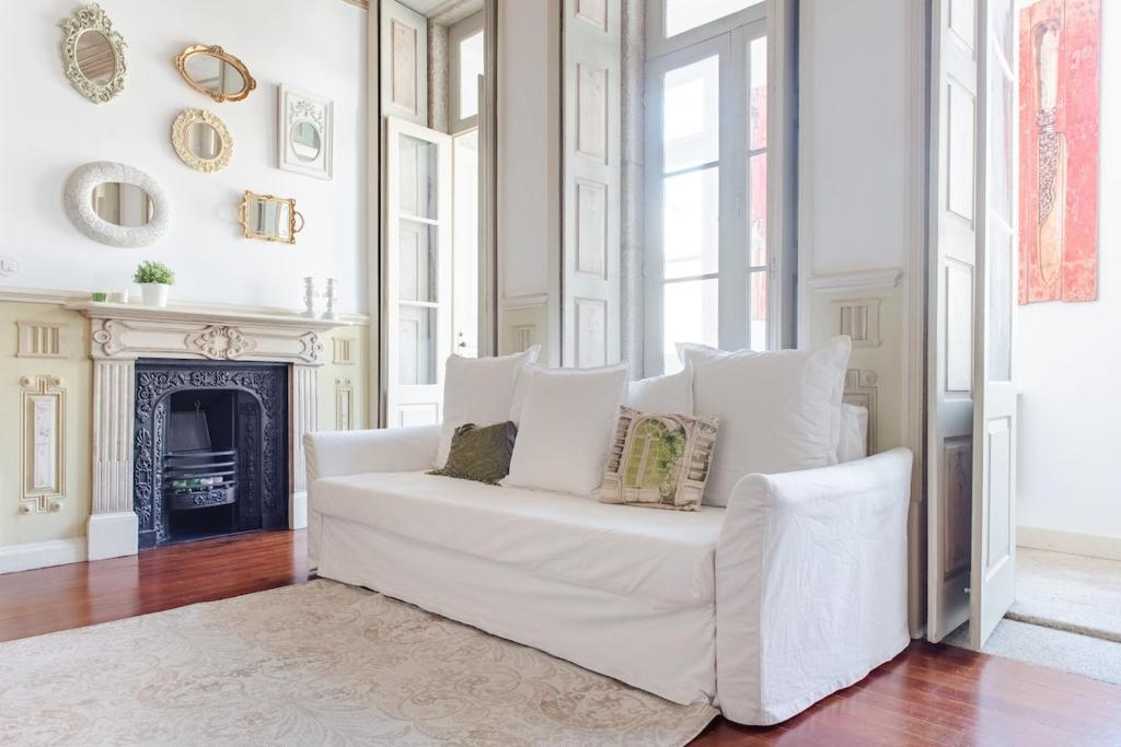 a white couch in a living room with a fireplace at Get a Unique and Luxury Flat in Porto