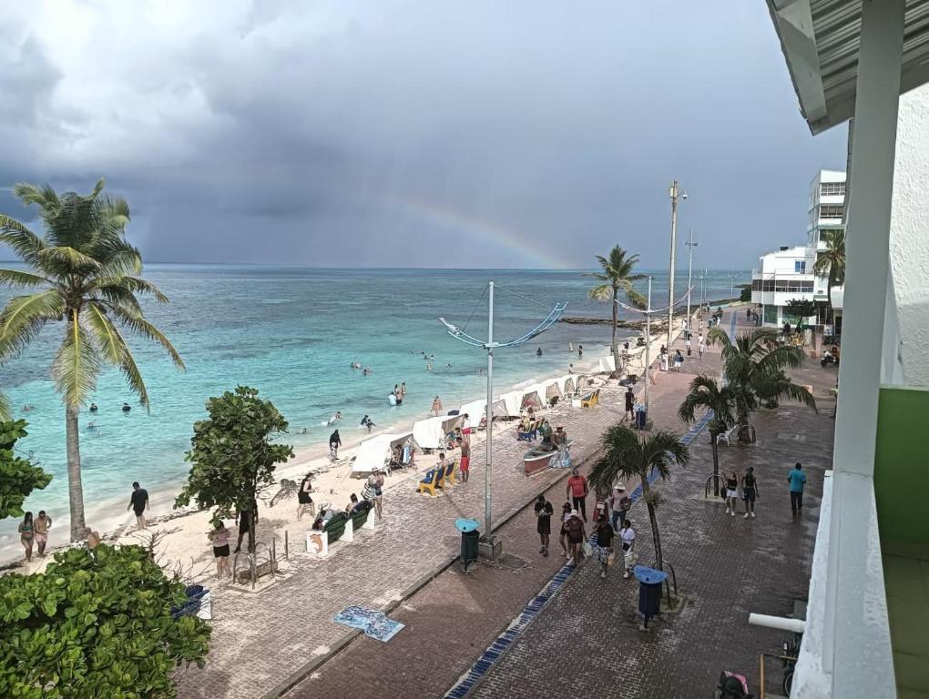 a group of people on a beach with the ocean at Borabora Hotel in San Andrés