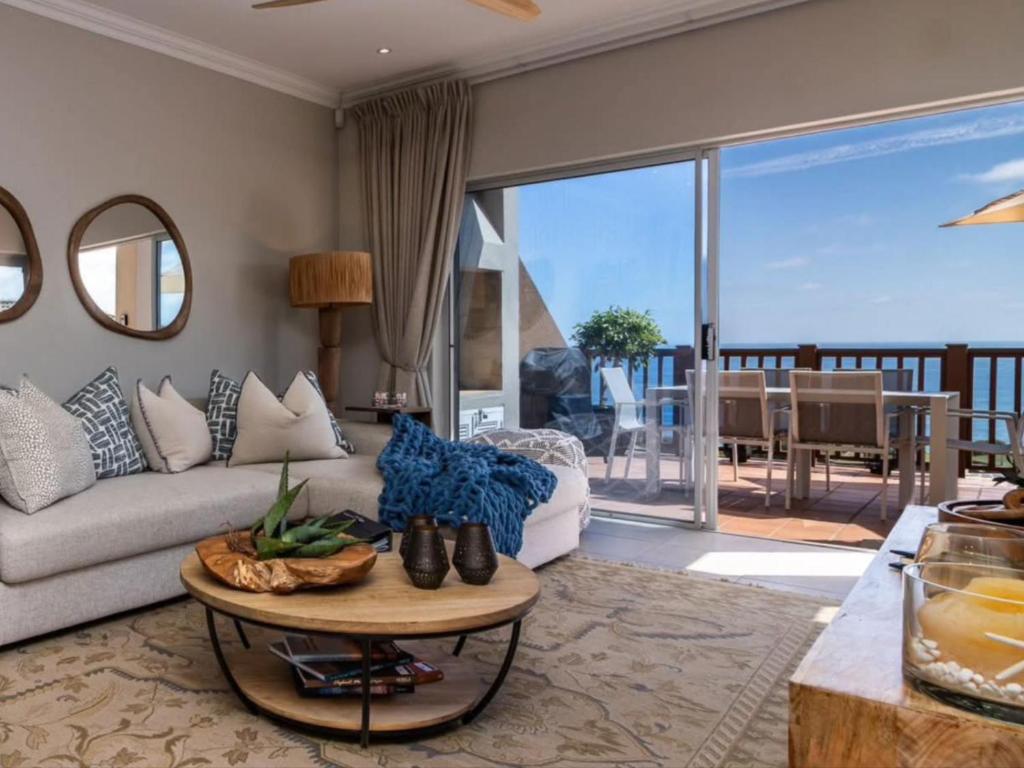 a living room with a couch and a table at Waves & Whales in Brenton-on-Sea