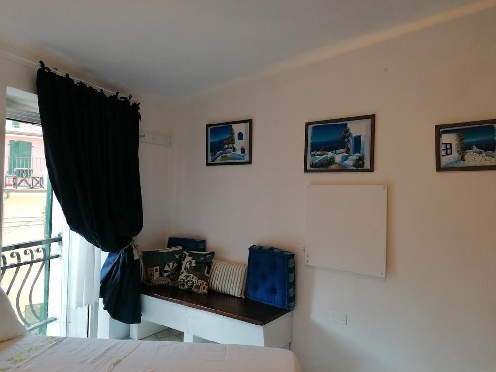 a bedroom with a bed and a window with a chair at la scogliera in Vernazza
