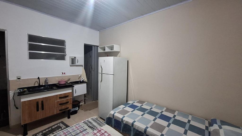 a small kitchen with a sink and a refrigerator at Casa kitnet in São Caetano do Sul