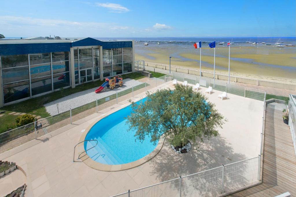 - une vue sur la piscine située à côté d'une plage dans l'établissement Résidence L'Océane, Andernos, à Andernos-les-Bains