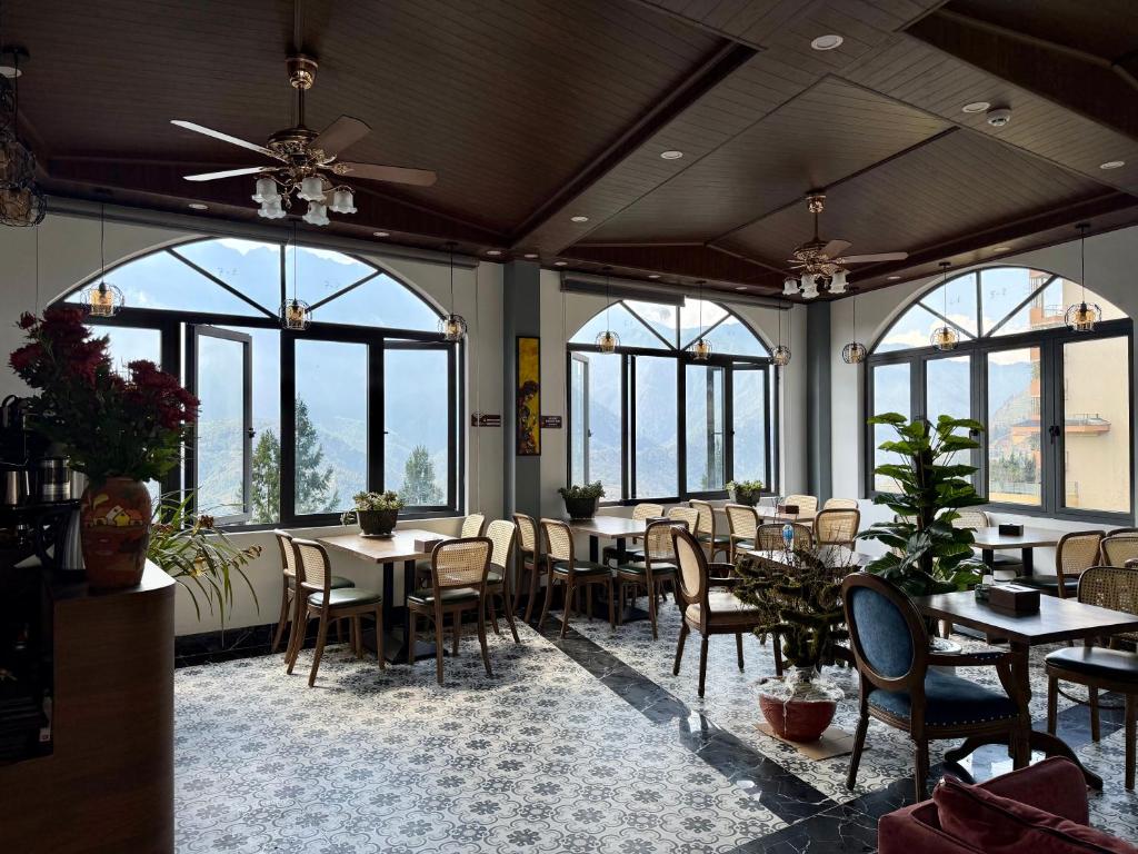 a dining room with tables and chairs and windows at Sapa Landscape Homestay in Sapa