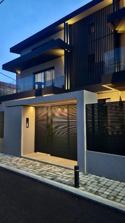a large building with a garage with a fence at Kalvokoresi 16 I Premium Apartments in Chios
