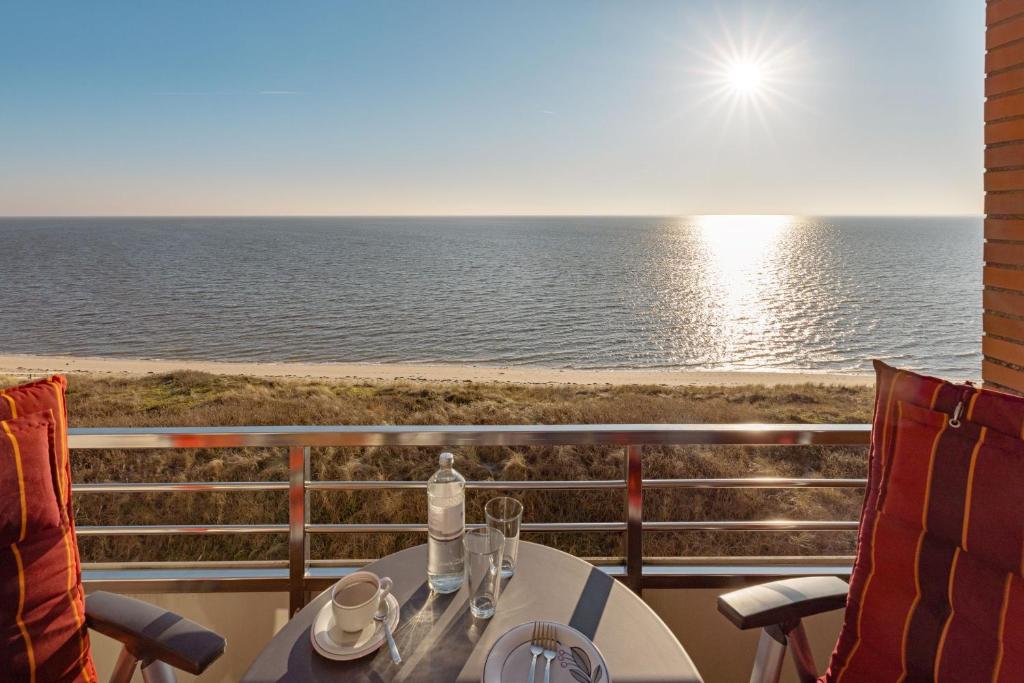 a table and chairs with a view of the ocean at Strandkieker in List