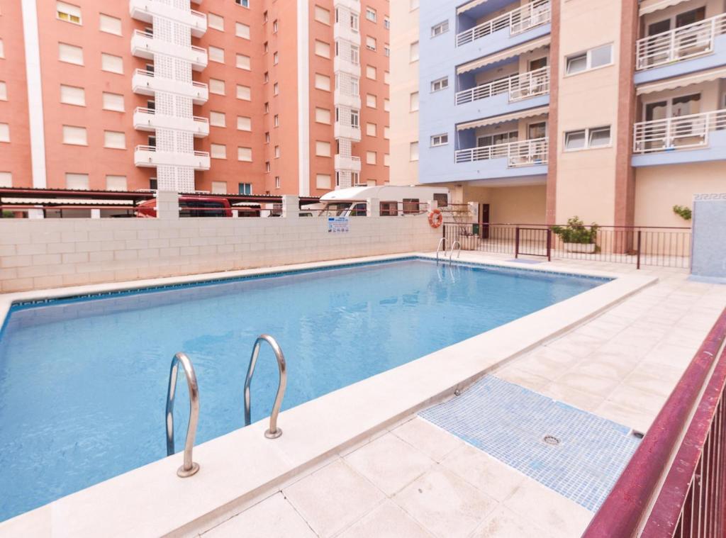 a swimming pool with buildings in the background at APCOSTAS Pereda Mar - Familiar in Puerto de Gandía