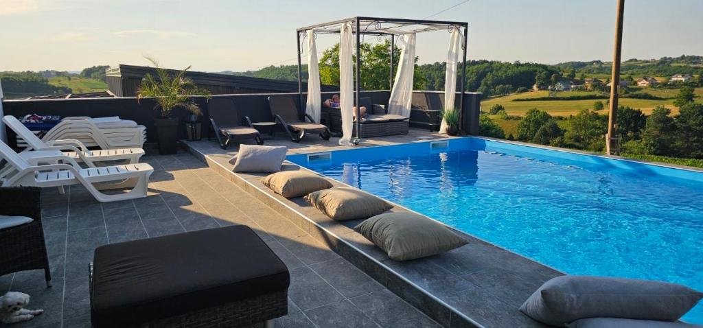 a swimming pool with lounge chairs at Villa Aida in Cazin