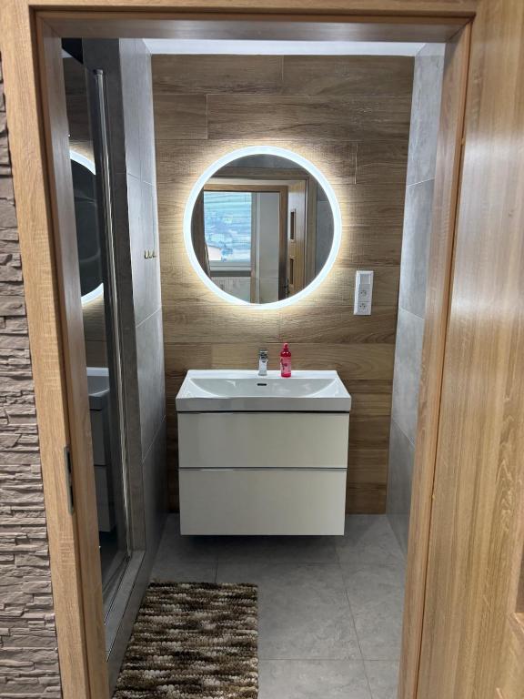 a bathroom with a white sink and a mirror at Apartmán Leo in Kežmarok