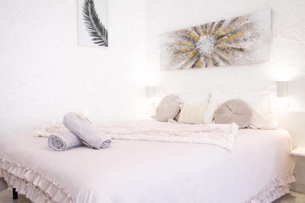 a white bedroom with a bed with towels on it at Studio confort, chic & spacieux Plage de Juan les pins & central in Juan-les-Pins