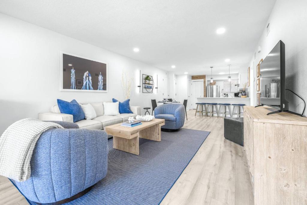 a living room with a blue couch and a tv at Golf Coast Bleu II - 3158 in Zephyrhills