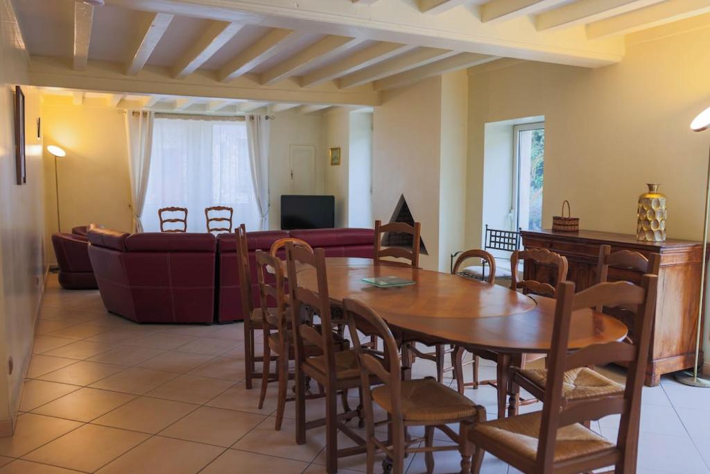 a living room with a table and chairs and a couch at L'Ancien Relais in Genouilly