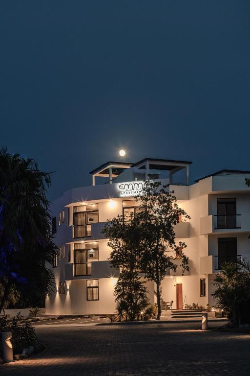 ein weißes Gebäude mit einem Schild darauf bei Nacht in der Unterkunft Emma Apartments - Akumal-Grand Sirenis in Akumal