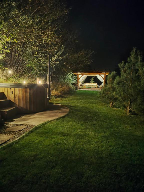 a garden at night with a fence and a gate at Domek Ponad Mgłami in Laskowa
