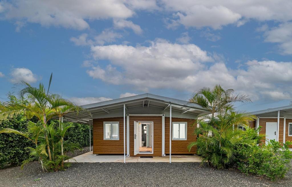 a small house with a wooden facade with trees at Tiny Homes Tamarindo in Tamarindo