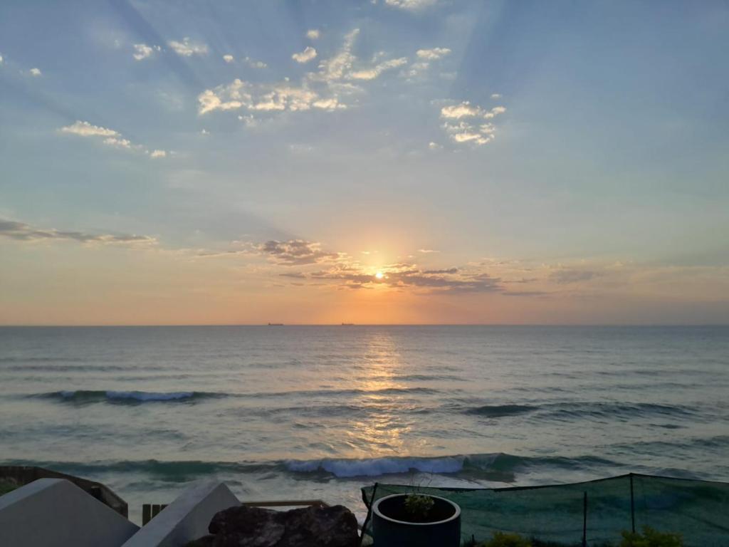 a sunset over the ocean with the sun setting at Khayalena Beach House - Tides Reach in Umdloti
