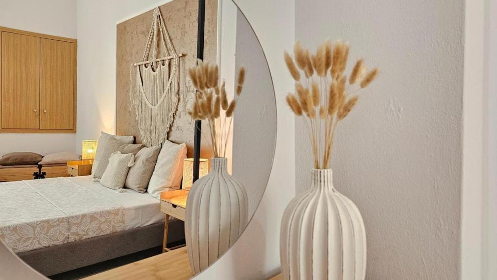 a bedroom with a bed and two vases on the floor at Plaka View Nest in Plaka Milou