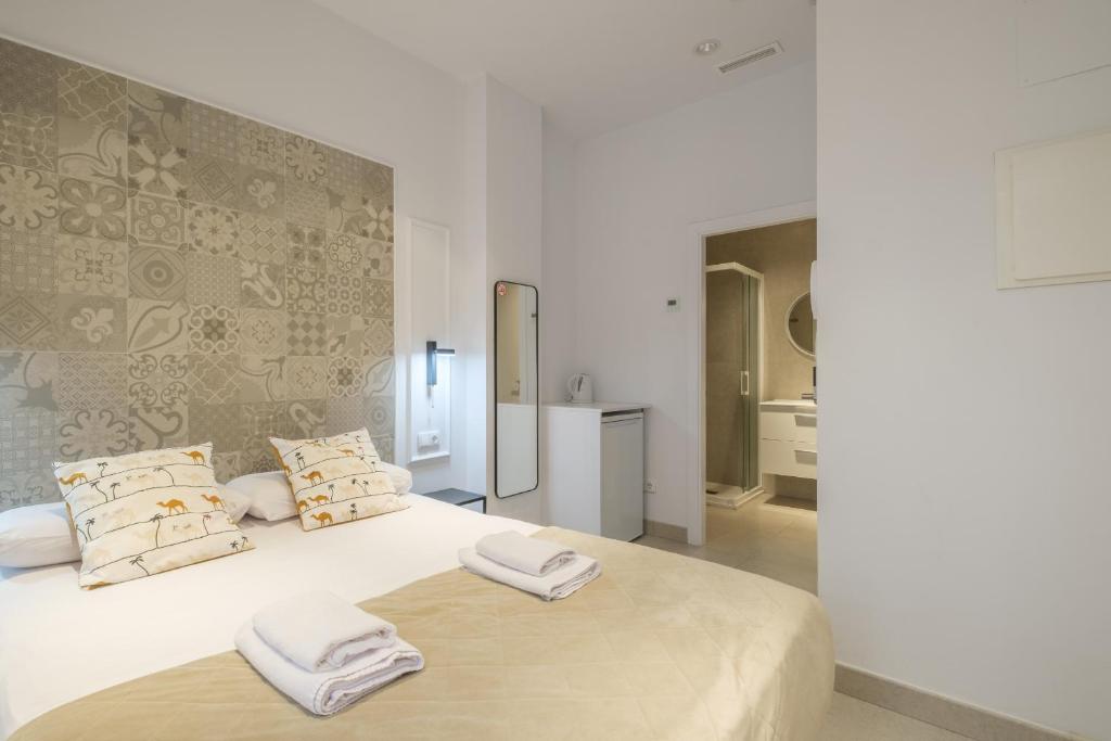 a bedroom with a large white bed with towels on it at Comfortable Room close to City Centre in Valencia