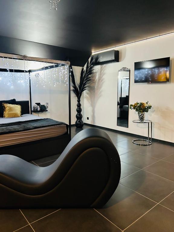 a black bedroom with a bed and a mirror at Le Bovary Hotel Suite Diamond in Héron