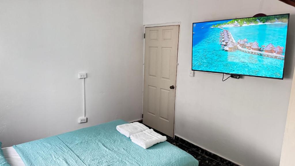 a bedroom with a tv hanging on a wall at Peace N' Green - APARTMENTS - Doleguita in David