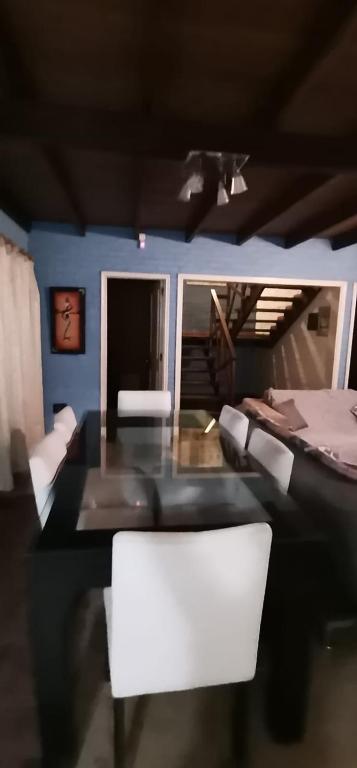 a dining room with a table and white chairs at blue beach in Rocha