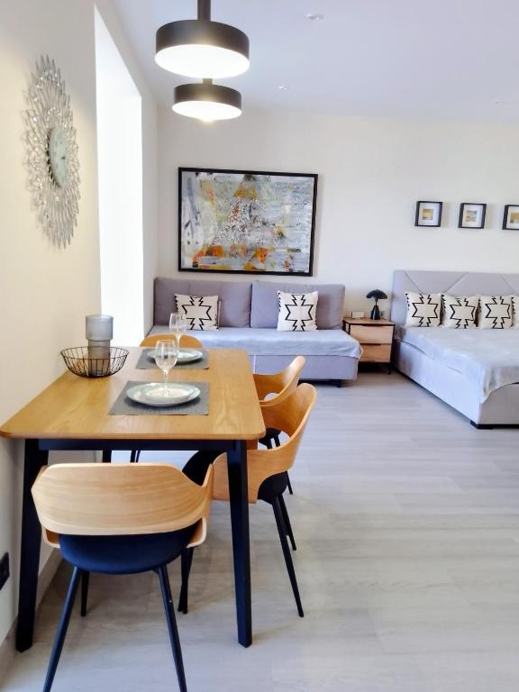 a living room with a table and a couch at Свіжі апартаменти в центрі міста новобудові на Проскурівське підпілля 110а in Khmelnytskyi