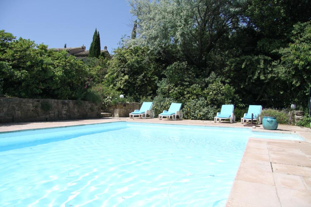 a swimming pool with blue lounge chairs in a yard at gite les Lavandes à Soyons, à proximité de Valence in Soyons