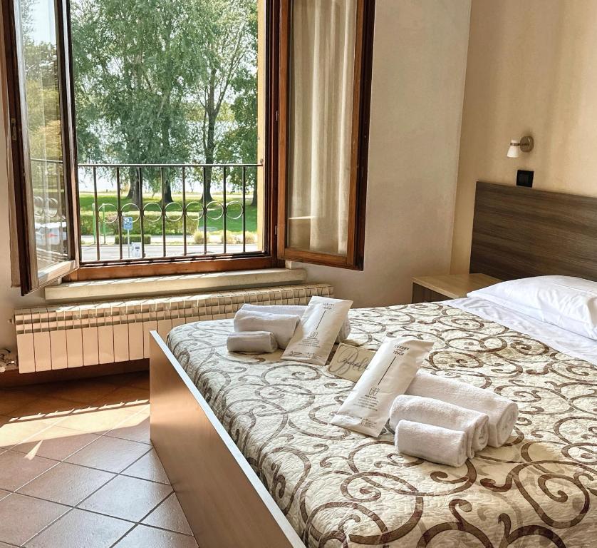 a bedroom with a large bed with pillows and a window at Residenza Bibiena - Lake View - in Mantova