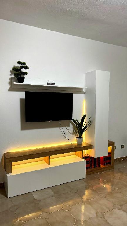 a living room with a flat screen tv on a wall at House Riky in Assemini