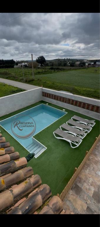 a swimming pool with a bunch of chairs on it at CHALET LOS PEPES in El Palmar