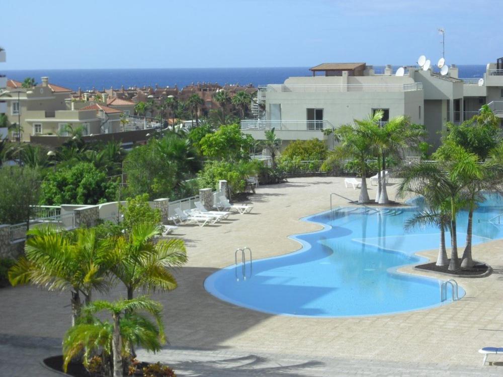 - Vistas a la piscina del complejo, con palmeras en Apartamento Sunset, en Palm-mar