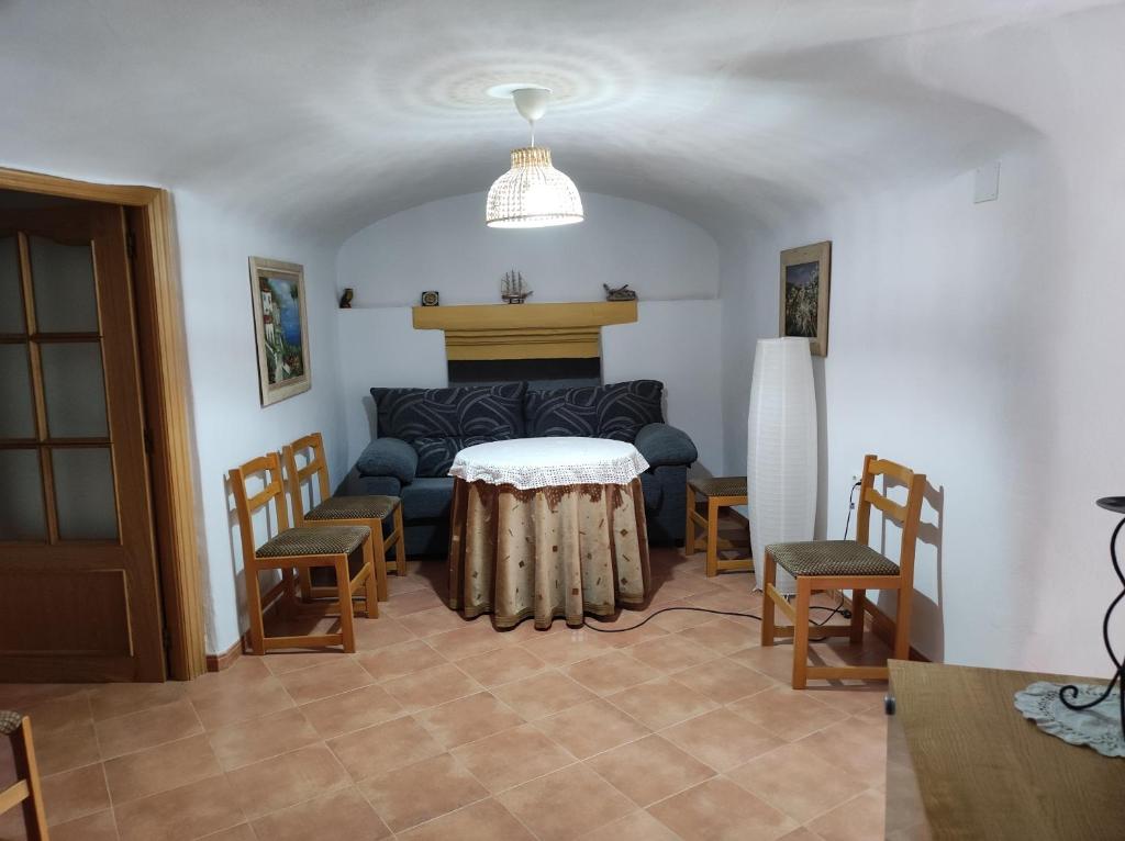 a living room with a couch and a table and chairs at El refugio de Águeda in Gorafe
