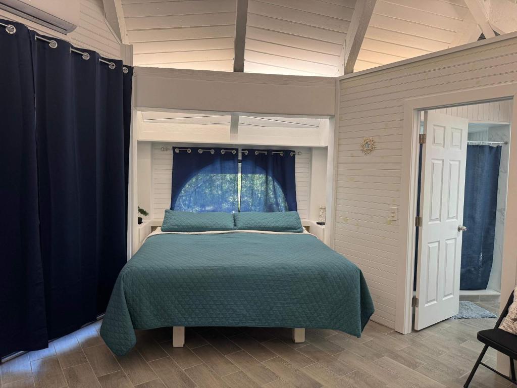 a bedroom with a bed with a blue comforter at Treehouse Private Village at Barnacle Resort in Big Pine Key