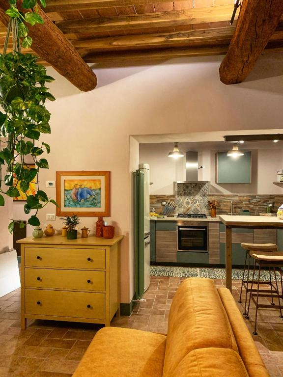 a living room with a couch and a kitchen at Guardastrada Country House in Monteroni dʼArbia