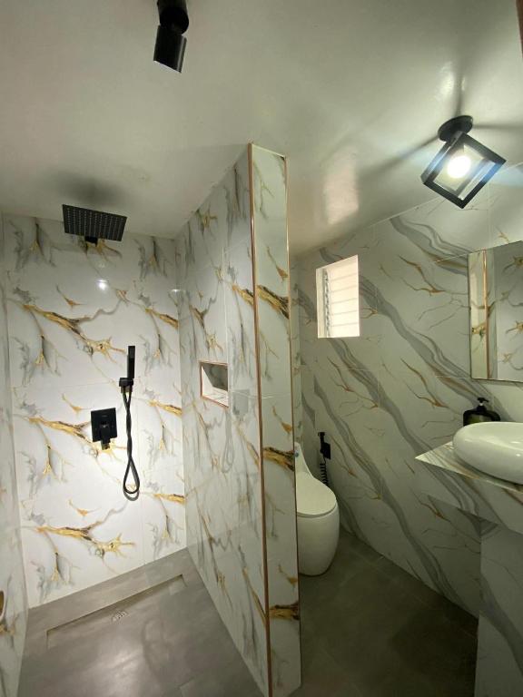 a bathroom with a toilet and a sink at NVH2 Coron Palawan in Coron