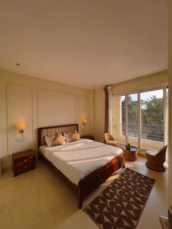 a bedroom with a large bed and a large window at Barylia in Mawlyngkhung