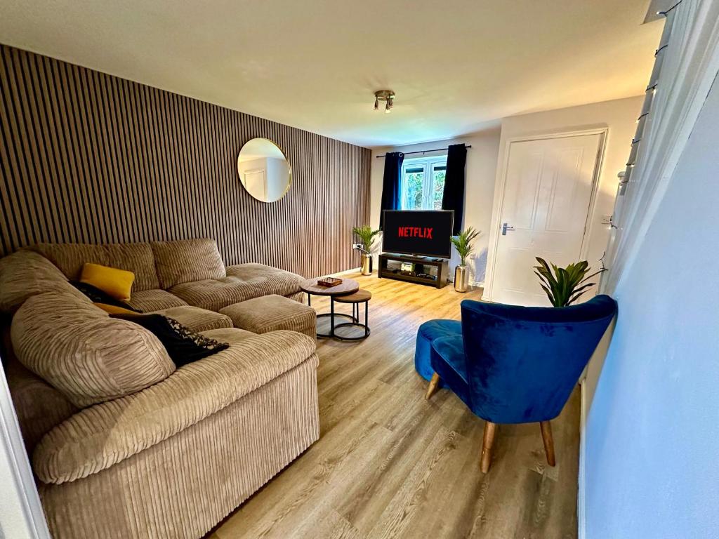 a living room with a couch and a blue chair at Serviced Accommodation, 3 Bed, allocated off road parking, Contractor Ready in Bedford